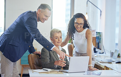 Buy stock photo Shot of a group of businesspeople using a laptop together in an office at work