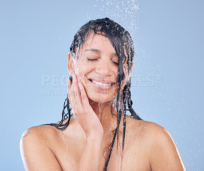 Buy stock photo Shot of a beautiful young woman taking a shower against a blue background