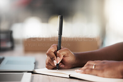 Buy stock photo Shot of an unrecognisable businesswoman making notes in a book in a modern office