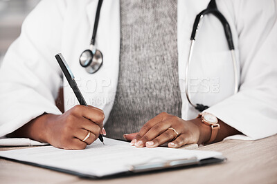 Buy stock photo Shot of an unrecognisable doctor making notes at her desk