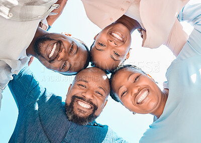 Buy stock photo Shot of four people standing in a huddle and looking down at the camera