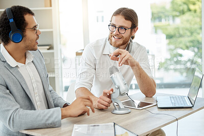 Buy stock photo Shot of two businessmen using a microphone during a broadcast in an office