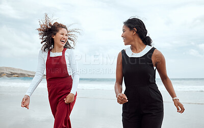 Buy stock photo Shot of two attractive young woman standing together on the beach