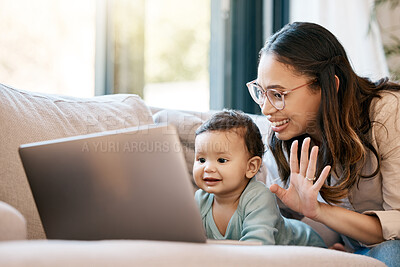 Buy stock photo Shot of a woman waving while sitting with her baby and looking at the laptop
