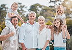 Multi-generation family standing together outside on a sunny day and smiling at the camera. Happy extended caucasian family having fun at the park