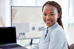 Portrait of african american businesswoman sitting alone in her office and using a computer. Smiling black professional feeling confident while using a laptop. Leading black entrepreneurs in business