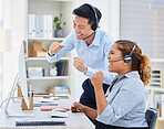 Two happy young diverse call centre telemarketing agent cheering with joy and punching the air with fists while working in an office. Excited african american and asian assistants celebrating successful sales and reaching targets to win