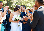 Bride and groom kissing after wedding ceremony while friends and family clap and celebrate their wedding day