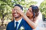 Playful bride covering grooms eyes from behind and surprising him. Happy couple on their wedding day. Taking first look at bride