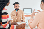 Group of diverse businesspeople having a meeting in a modern office at work. Young mixed race businessman talking about an idea sitting in a boardroom with colleagues. Creative businesspeople planning together