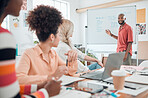Group of diverse businesspeople having a meeting in a modern office at work. Young african american businessman smiling while doing a presentation of an idea on a whiteboard in a boardroom with colleagues. Businesspeople planning together