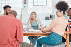 Group of happy diverse businesspeople having a meeting in a modern office at work. Joyful colleagues laughing and talking while sitting at a table. Creative businesspeople planning together
