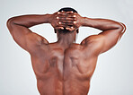 Rear view of one African American fitness model posing against a white background. Unrecognizable black man showing off his muscular shape while  isolated on white copyspace