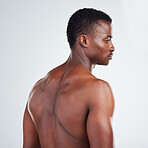 One African American fitness model posing against a white background. Confident young black man showing off his muscular shape while isolated on white copyspace in a studio