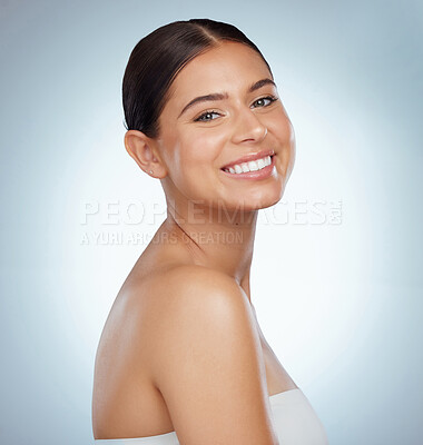 Buy stock photo Portrait of a beautiful woman with smooth glowing skin and copyspace posing. Headshot of a smiling caucasian model isolated against a grey studio background. Young woman with healthy skincare routine