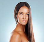 Portrait of a hispanic brunette woman with long lush beautiful hair posing against a grey studio background. Mixed race female standing showing her beautiful healthy hair