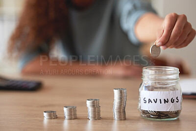 Buy stock photo One unknown mixed race woman depositing coins into a savings jar at home. Hispanic woman counting money and stacking coins while calculating her finance budget. Earning interest for growth and profit 