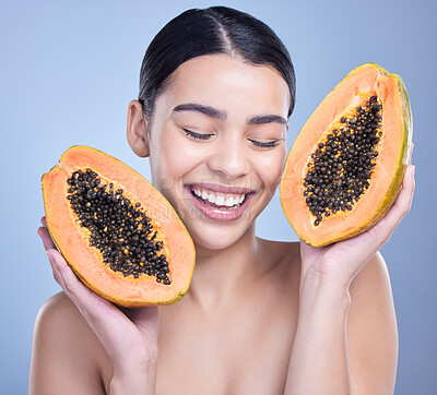 Buy stock photo A happy smiling mixed race woman holding a papaya. Hispanic model promoting the skin benefits of a healthy diet against a blue copyspace background