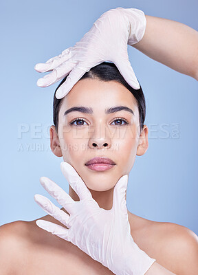 Buy stock photo Studio portrait of a gorgeous mixed race woman getting botox filler. Hispanic model getting cosmetic surgery against a blue copyspace background