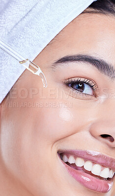 Buy stock photo Studio Portrait of a beautiful mixed race woman applying a soothing face serum to her radiant smooth face while wearing a towel on her head. Hispanic woman with flawless skin using essential oil