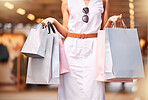 Cropped closeup view of a unrecognizable woman carrying bags during a shopping spree. Unrecognizable woman shopping in a mall while holding purchased items. A little retail therapy day is never a bad idea