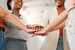 Group of businesswomen stacking their hands together in an office at work. Diverse group of businesspeople having fun standing with their hands stacked in unity