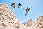 Young man showing his cycling skills while out cycling on a bicycle outside. Adrenaline junkie practicing a dirt jump outdoors. Wearing a helmet doing tricks with a bike. Extreme sports on a mountain