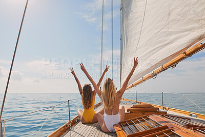 Buy stock photo Two cheerful friends with arms raised making peace signs celebrating on boat cruise together. Two excited women in swimwear on holiday cruise celebrating cheering making peace signs in the air