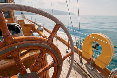 Buy stock photo Closeup of wooden steering wheel on empty boat sailing the ocean. Closeup of empty boat deck with rigging cables wooden steering wheel sailing the ocean.