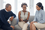 Three happy diverse businesspeople brainstorming and working on a digital tablet together at work. Young african american businesswoman showing her hispanic colleagues an idea on her digital tablet
