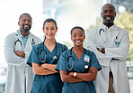 Group of happy doctors and nurses standing in a line with their arms crossed while working at a hospital. Content expert medical professionals smiling at work together at a clinic