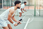 Two ethnic tennis players holding rackets and ready to play court game. Serious, focused athletes together in stance. Playing competitive doubles match as team to stay fit and healthy in sports club