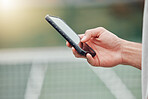Closeup of unknown mixed race tennis player using cellphone during break in game on court. Hispanic fit athlete browsing internet and networking on phone after match. Active healthy man in sports club