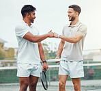 Two smiling ethnic tennis players giving fistbump with fist before playing court game. Fit athletes team standing and using hand gesture for good luck. Play competitive sports match for health fitness
