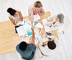 Group of five diverse businesspeople having a meeting at a table in an office from above. Happy colleagues shaking hands while their coworkers clap for them