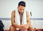 Hispanic player with his eyes closed in a locker room. Young man sitting and thinking in a gym. Athlete getting ready before a match. Fit man preparing for a match at the gym