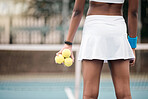 Closeup on the hands of a tennis player holding tennis balls. Tennis player standing on the court at the club. Tennis player ready for practice. Back of tennis player ready to compete