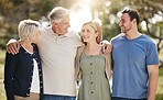 Happy loving caucasian family with adult children standing together in nature on a sunny day.  Happy senior couple posing outdoors with their daughter and son in law