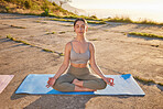 Full length yoga woman meditating with legs crossed for outdoor practice in remote nature. Caucasian mindful active person sitting alone and balancing for mental health. Young, focused, serene and zen