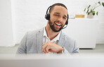 Young happy mixed race male call center agent answering calls while wearing a headset at work. Hispanic businessman talking on a call while working on a desktop computer at a desk in an office