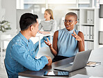 Two businesspeople having a meeting together in an office at work. Young african american businesswoman talking to an asian businessman. Colleagues sitting and planning at work