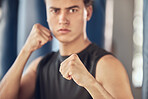 Portrait of serious boxer in the gym. Young bodybuilder ready for boxing workout. Fit man mma training in the gym. Athlete ready for cardio combat training. Young man ready to punch