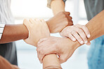 Closeup of diverse group of people holding each other's wrists in a circle to express unity, support and solidarity. Connected hands of multiracial community linked for teamwork in a huddle. Society join together for collaboration and equality