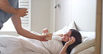 A young man waking up his girlfriend with a cup of coffee and breakfast in bed