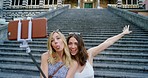 Two cheerful women taking selfies on holiday together in Italy while in front of a church