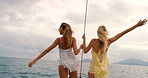 Carefree happy women on a yacht cruise enjoying the view together. Two happy friends on a holiday cruise on a yacht enjoying the view. Happy friends on a holiday cruise together on a yacht